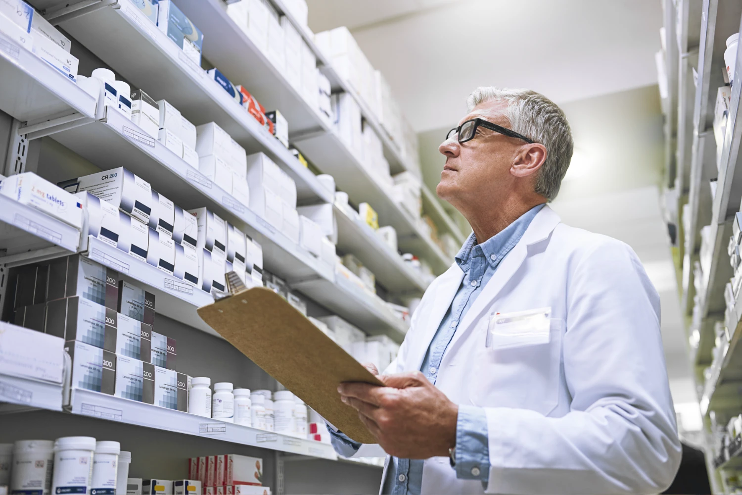 Farmacéutico revisando inventario de medicamentos en anaquel